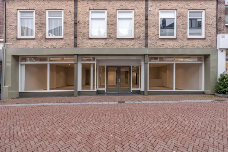 De gevel van Peperstraat 11-15, waar Luma Studios komt: een bakstenen pand met grote ramen op de begane grond en daarachter een lege ruimte.